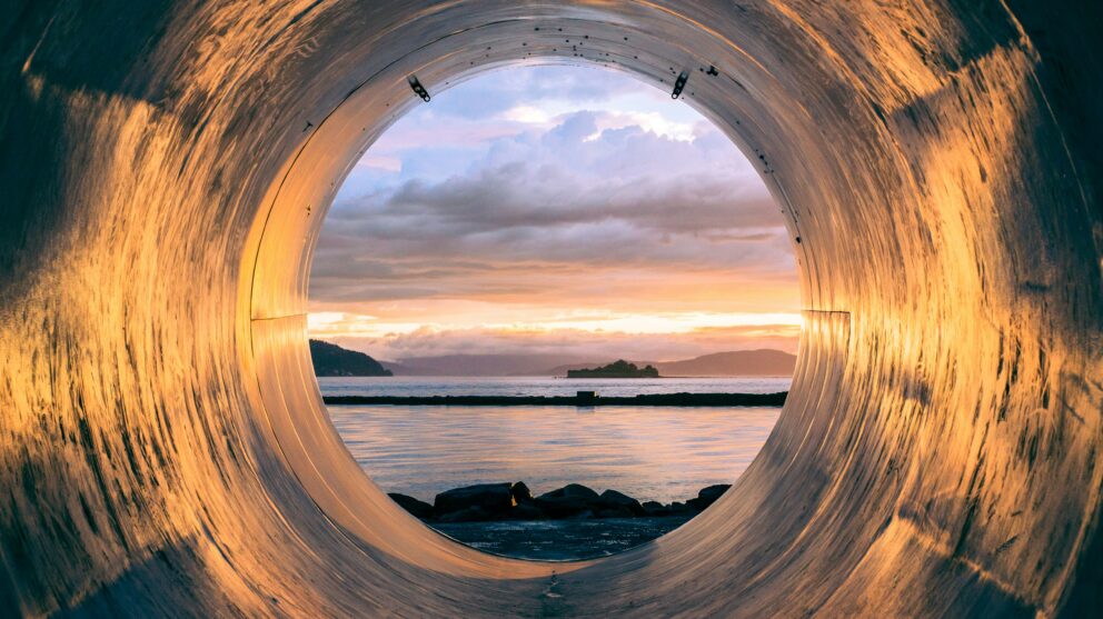 World Water Week image showing a body of water seen through the open end of a water pipe